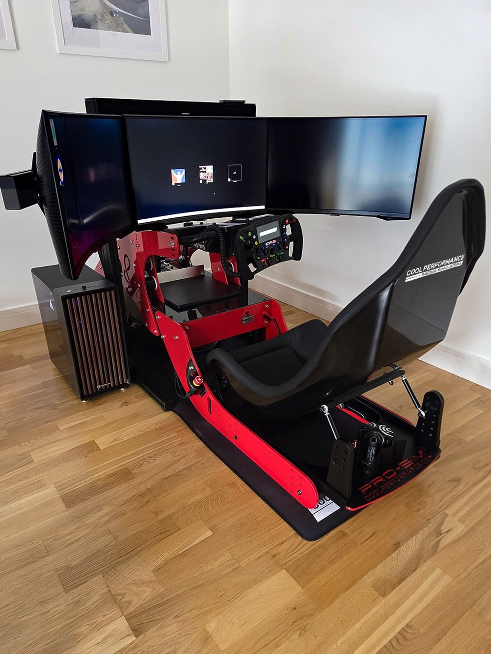 Formula Pro in Rosso Corsa red with carbon fibre trim and triple curved monitors in a home