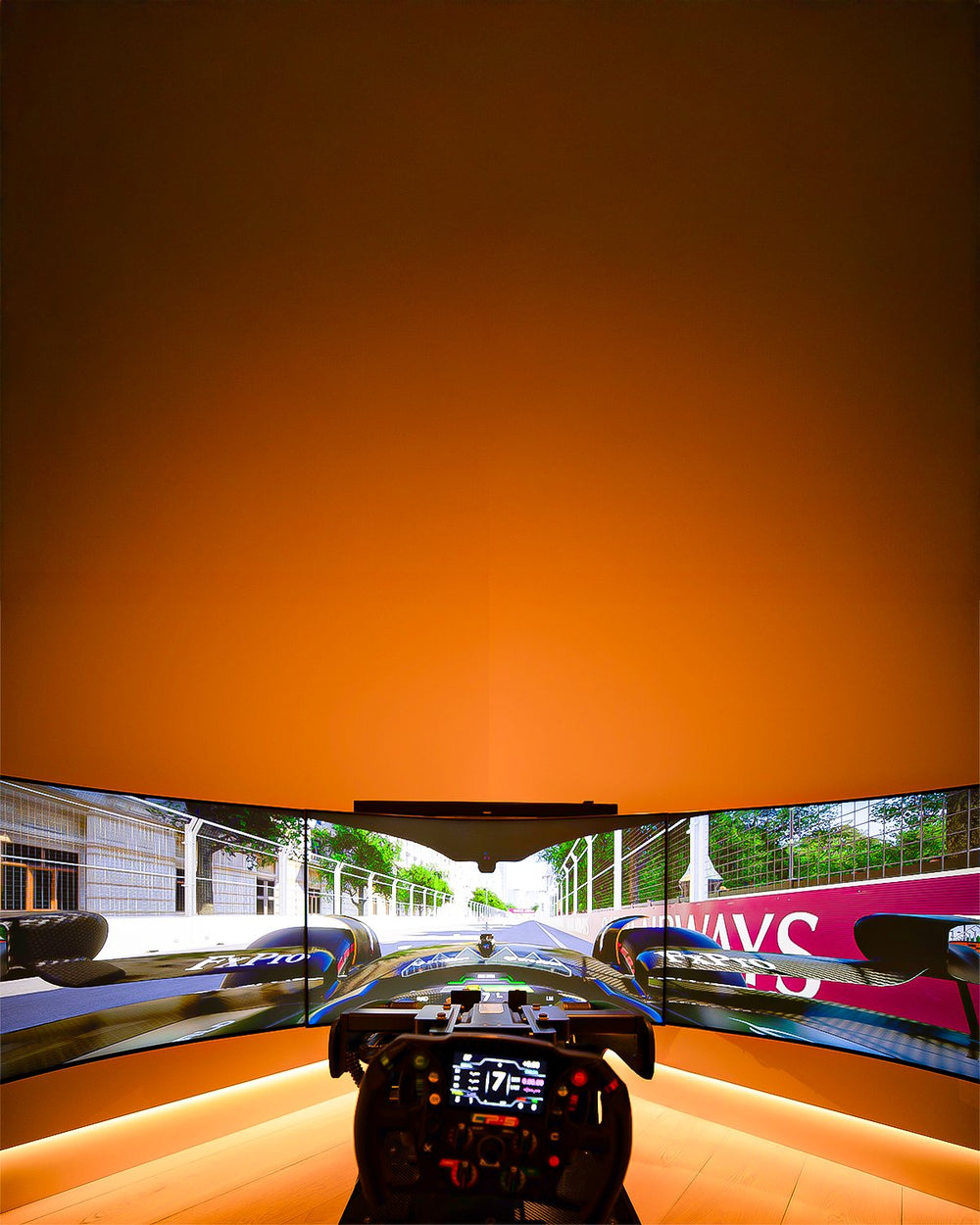 Black Formula Pro with D-Box motion and triple Ark monitors in a home sim room with warm LED lighting