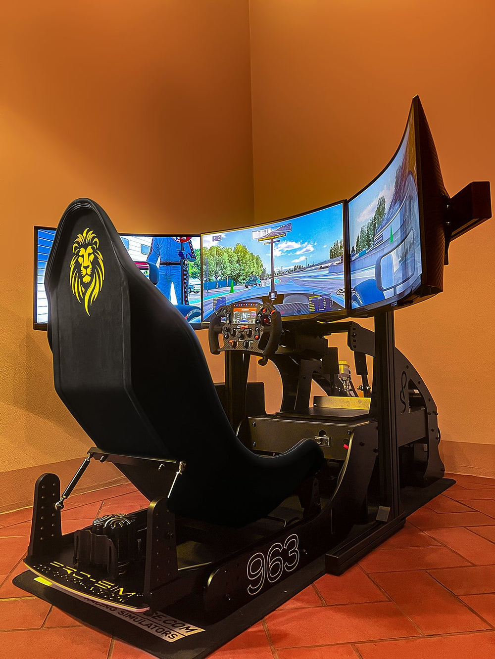 Stealth black Formula Pro with yellow highlights and triple 27 inch monitors in a home, Italy